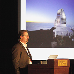 Presenter in front of telescope